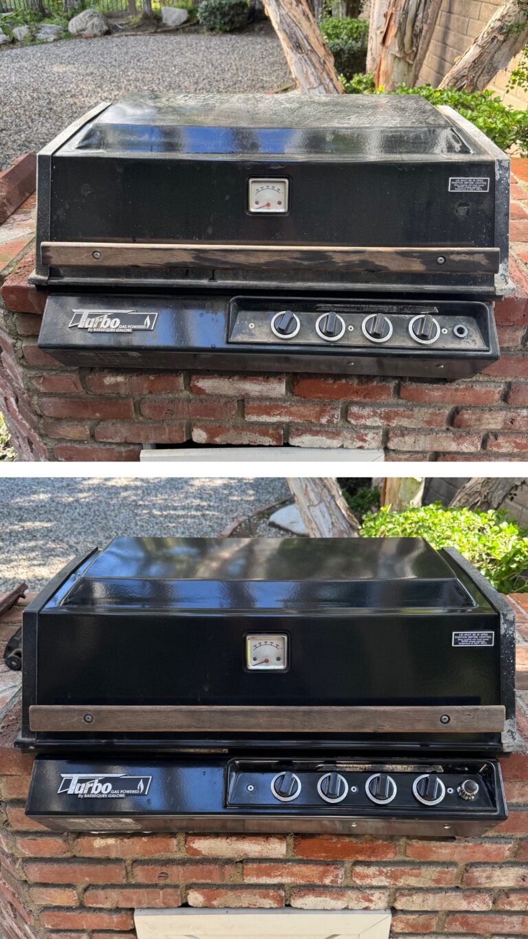 A black Turbo barbecue grill with four control knobs, set on a brick base in a sunlit backyard. Surrounding greenery adds a natural touch.